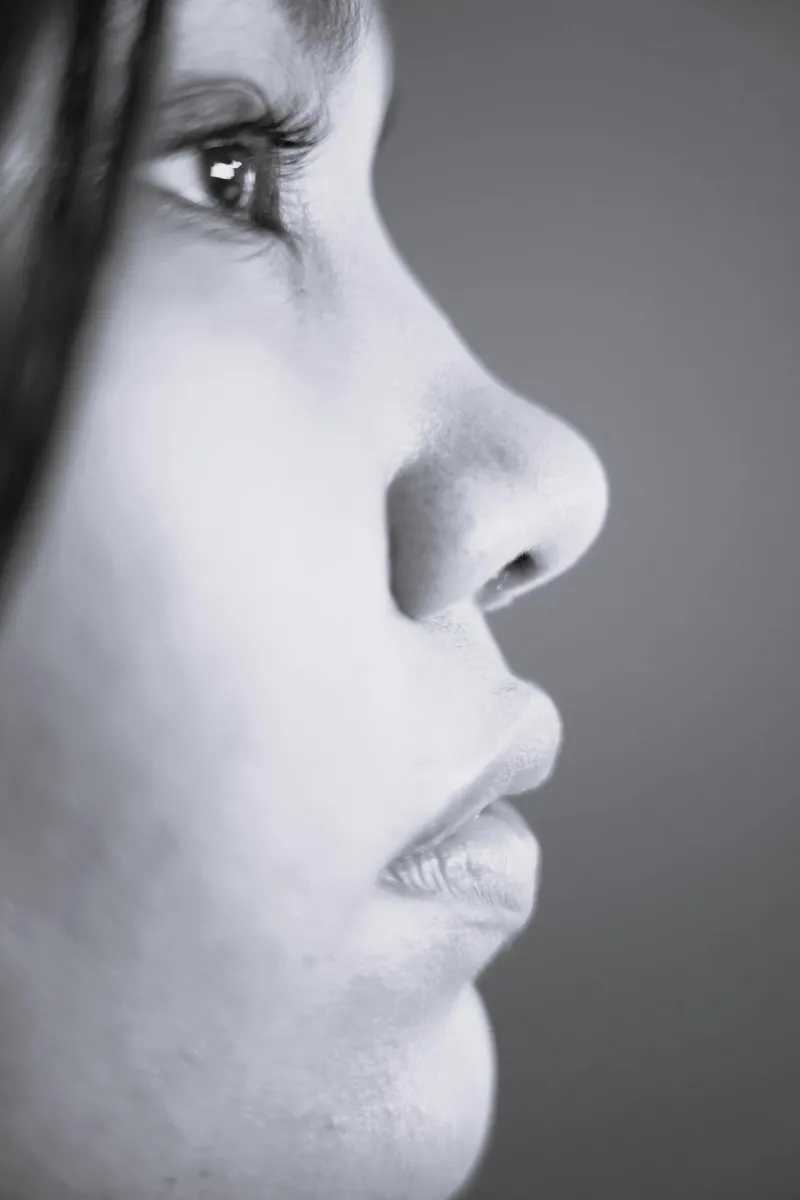 Editorial profile of a woman in soft light, turned toward the left.